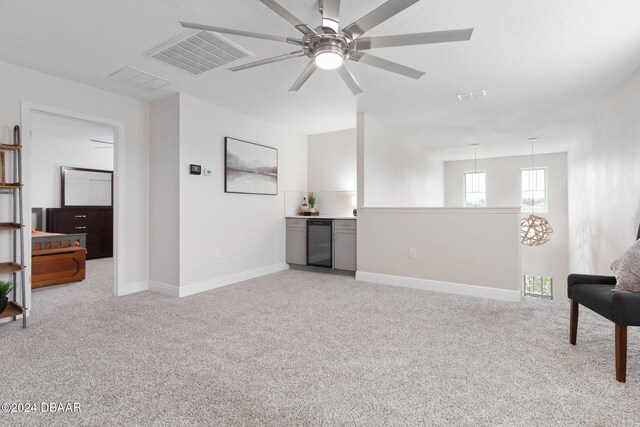 118 Pitching Wedge Dr, Daytona Beach, FL 32124 - sitting room with light carpet, wine cooler, a ceiling fan, and a dry bar