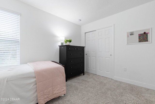 bedroom featuring light colored carpet and a closet