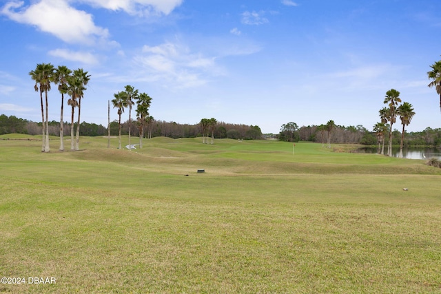 surrounding community with a yard and a water view