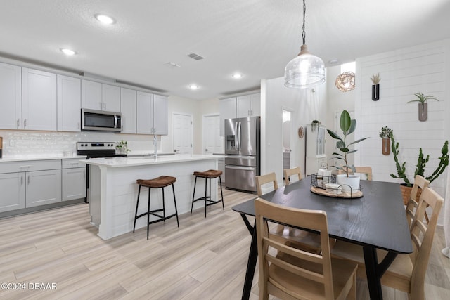 dining room featuring a textured ceiling and light hardwood / wood-style flooring