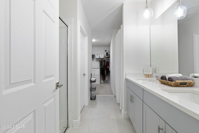 bathroom featuring tile patterned floors, vanity, and a shower with door