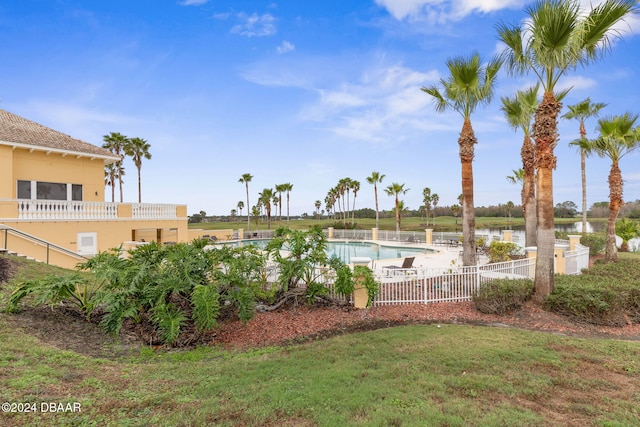 view of swimming pool with a water view and a yard