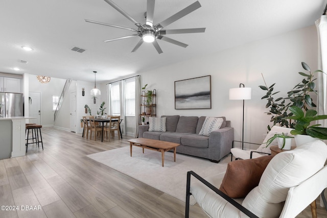 living room featuring light hardwood / wood-style flooring and ceiling fan