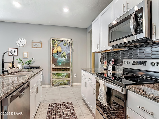 330 Charles Dr, Deland, FL 32724 - kitchen featuring stainless steel appliances, a sink, tasteful backsplash, dark stone counters, and white cabinets