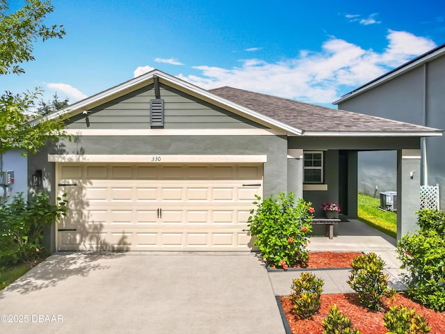 330 Charles Dr, Deland, FL 32724 - view of front facade featuring a garage, driveway, stucco siding, and a shingled roof