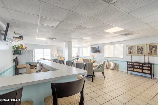 tiled dining space featuring a paneled ceiling