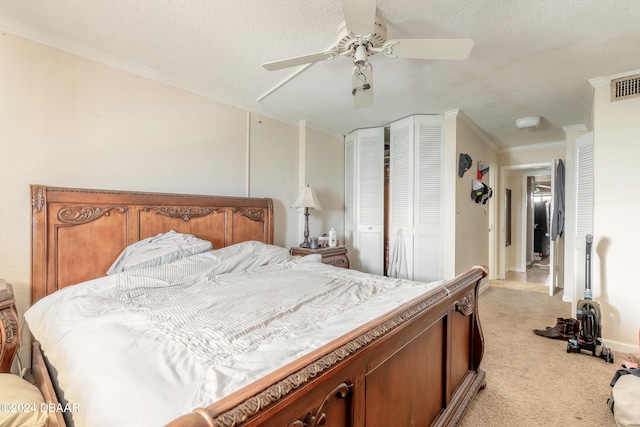 carpeted bedroom with ceiling fan, a textured ceiling, and crown molding