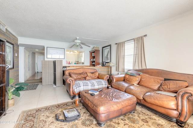 living room featuring ornamental molding, a textured ceiling, ceiling fan, and light tile patterned floors