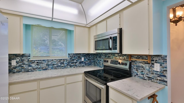 kitchen with tasteful backsplash, stainless steel appliances, and white cabinets