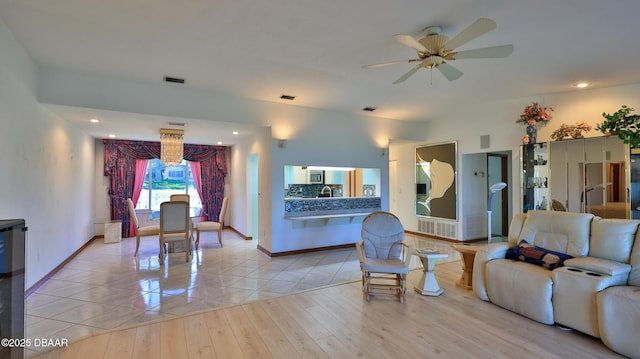 living room featuring light tile patterned floors, sink, and ceiling fan