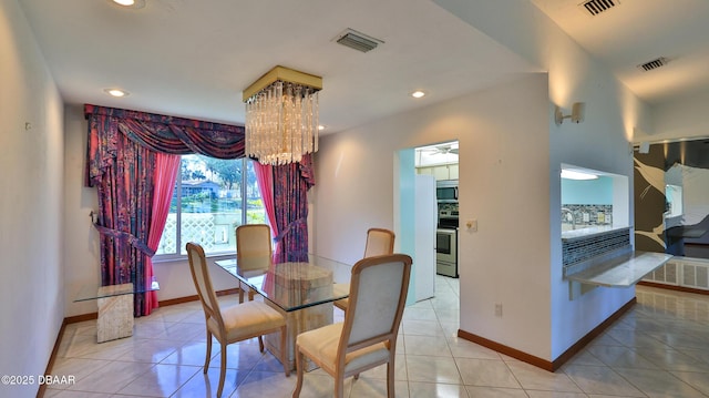 tiled dining room with a chandelier