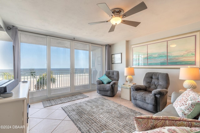 tiled living room with a water view and ceiling fan