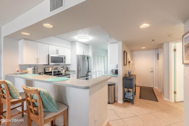 4641 S Atlantic Ave Unit 3060, Ponce Inlet, FL 32127 - kitchen featuring appliances with stainless steel finishes, light countertops, a peninsula, light tile patterned flooring, and recessed lighting