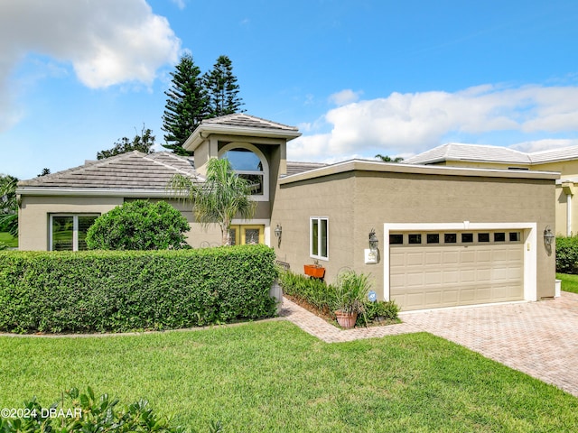 mediterranean / spanish-style house featuring a garage and a front yard