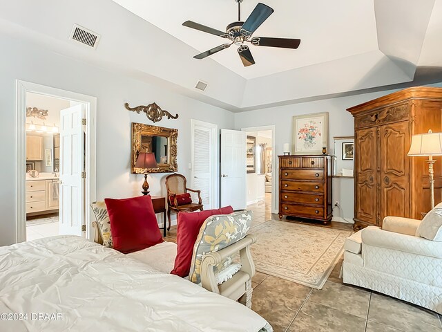 tiled bedroom with lofted ceiling, ceiling fan, and ensuite bath