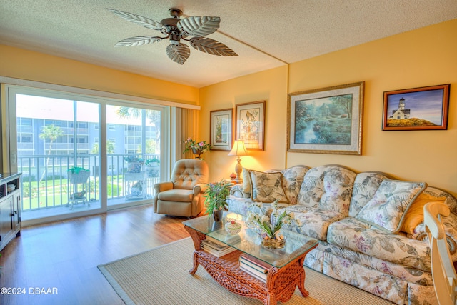 living room with ceiling fan, hardwood / wood-style floors, and a textured ceiling