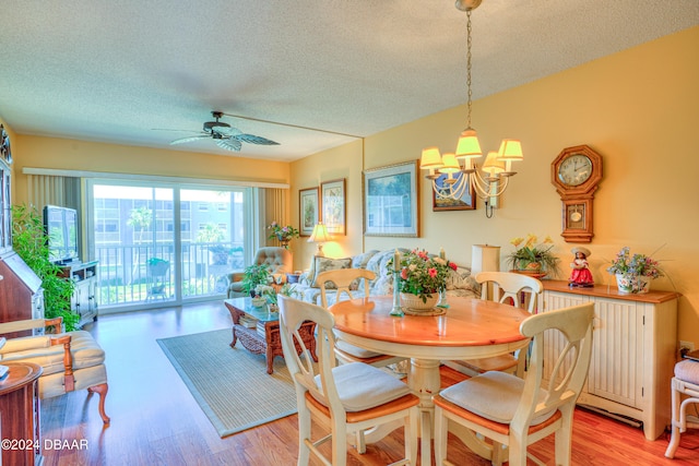 dining area with ceiling fan with notable chandelier, a textured ceiling, and light wood-type flooring