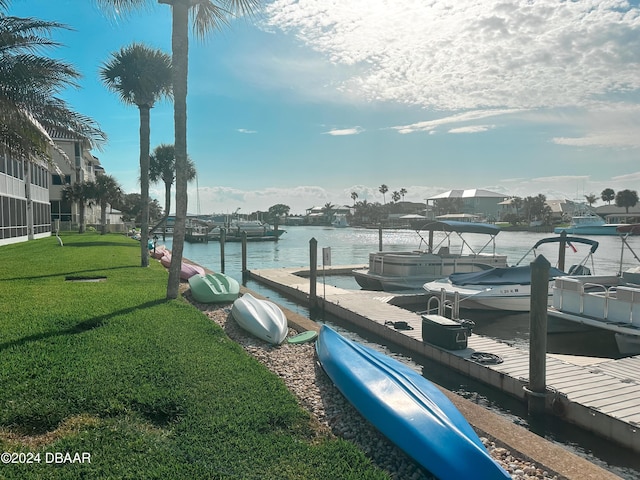 view of dock with a water view and a yard