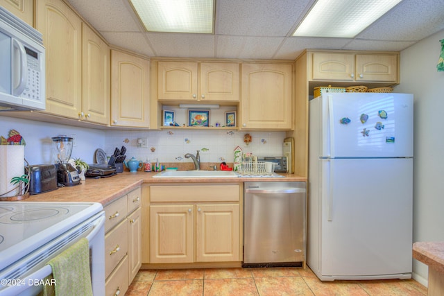 kitchen with decorative backsplash, a drop ceiling, white appliances, sink, and light tile patterned floors