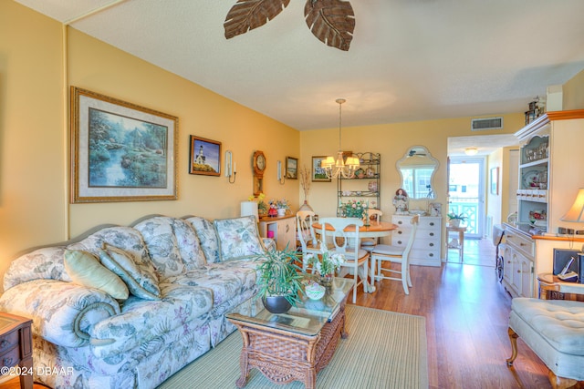 living room with a textured ceiling, a notable chandelier, and hardwood / wood-style flooring