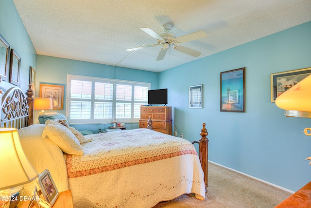 carpeted bedroom with ceiling fan and a textured ceiling