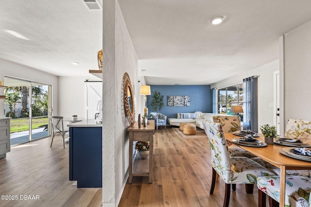 dining area featuring hardwood / wood-style flooring and a textured ceiling