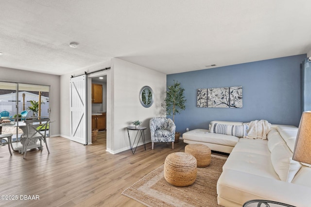 living room with hardwood / wood-style flooring, a barn door, and a textured ceiling