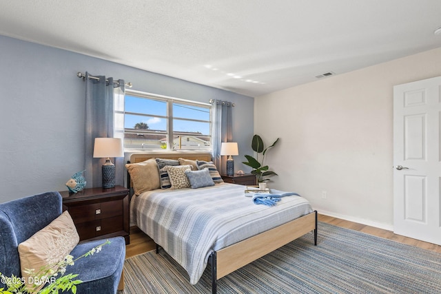 bedroom featuring hardwood / wood-style floors and a textured ceiling