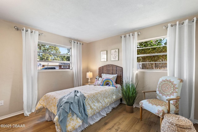 bedroom with wood-type flooring and a textured ceiling