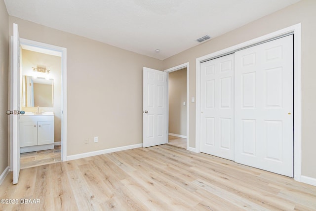 1808 Green Pl, Ormond Beach, FL 32174 - unfurnished bedroom featuring light wood-style floors, a sink, baseboards, and a closet