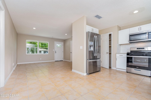 1808 Green Pl, Ormond Beach, FL 32174 - kitchen with stainless steel appliances, white cabinetry, light tile patterned floors, recessed lighting, and tasteful backsplash