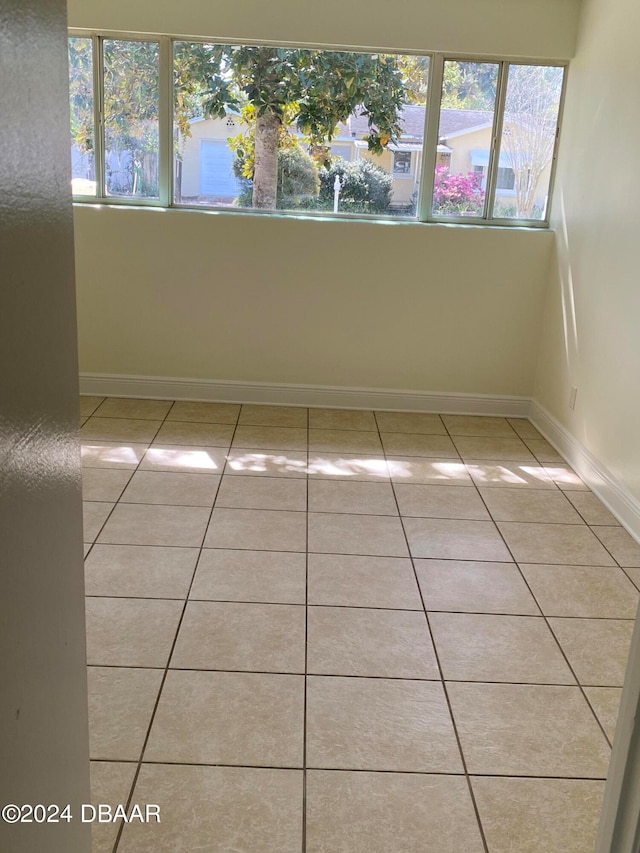 unfurnished room with light tile patterned floors and a healthy amount of sunlight