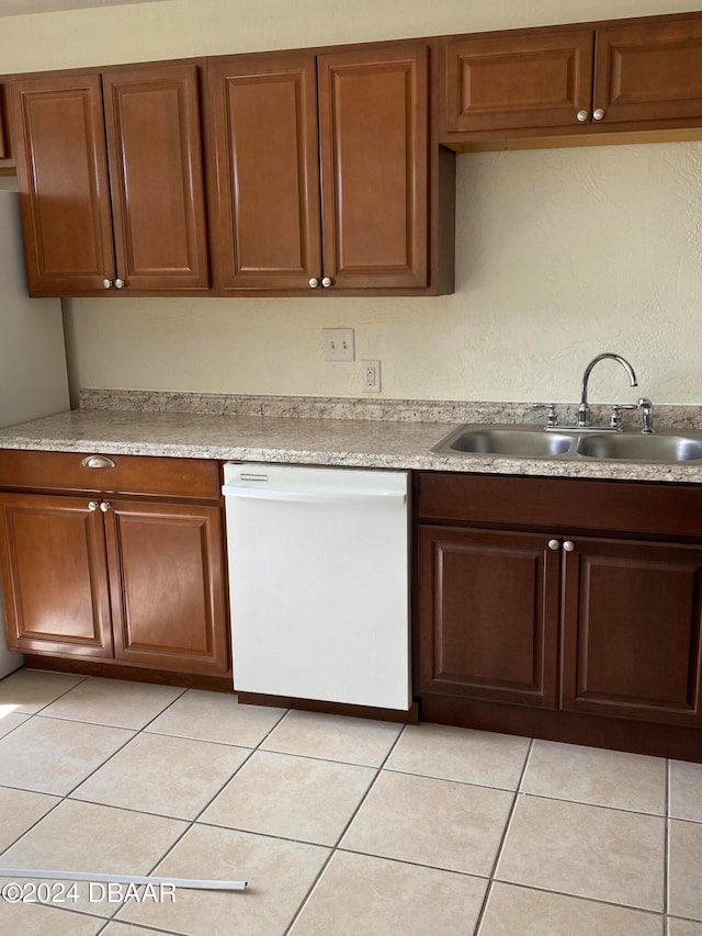 kitchen featuring white dishwasher, light tile patterned flooring, and sink