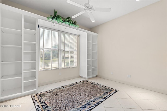 unfurnished room with tile patterned flooring, baseboards, and a ceiling fan