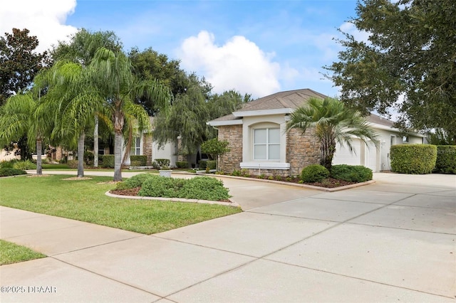view of front of property with driveway, stone siding, a front yard, and a garage