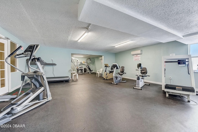 exercise room with a wall mounted AC and a textured ceiling