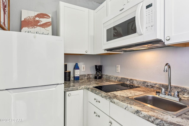 kitchen featuring white appliances, white cabinetry, and sink