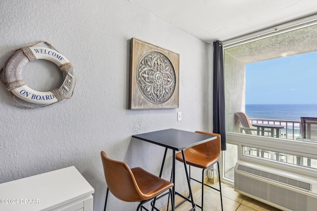 dining room featuring a water view and light tile patterned flooring