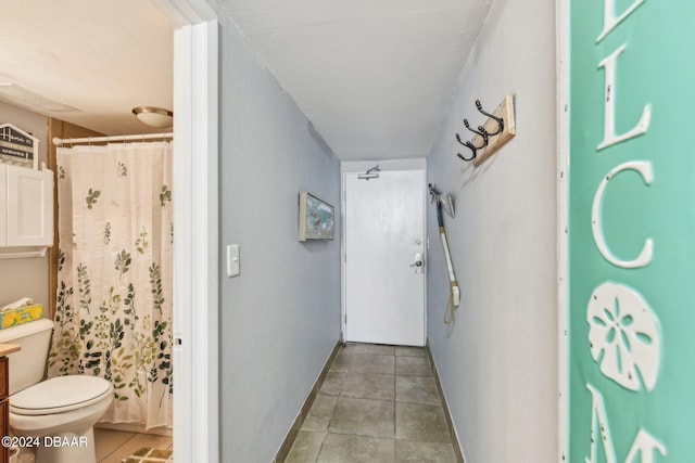 bathroom with tile patterned floors, curtained shower, and toilet