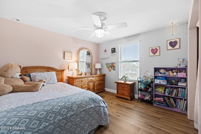 bedroom featuring light hardwood / wood-style floors and ceiling fan with notable chandelier