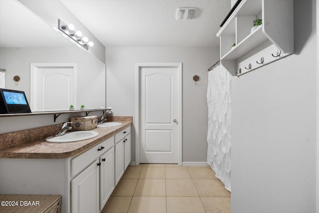 bathroom featuring vanity, a textured ceiling, and tile patterned flooring