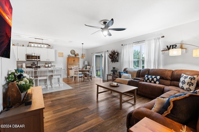 living room with dark hardwood / wood-style flooring and ceiling fan