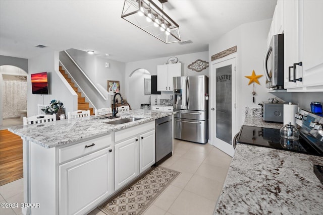 kitchen featuring white cabinets, a center island with sink, and stainless steel appliances