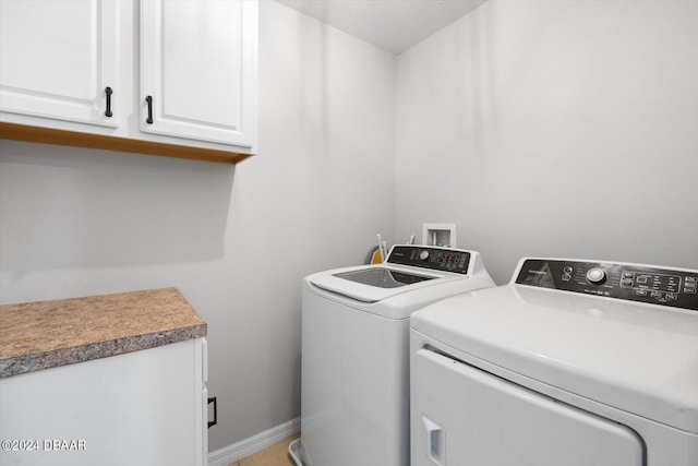 laundry area with cabinets, independent washer and dryer, and a textured ceiling