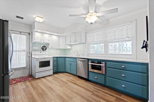 kitchen featuring ceiling fan, sink, hardwood / wood-style flooring, white electric range, and white cabinetry