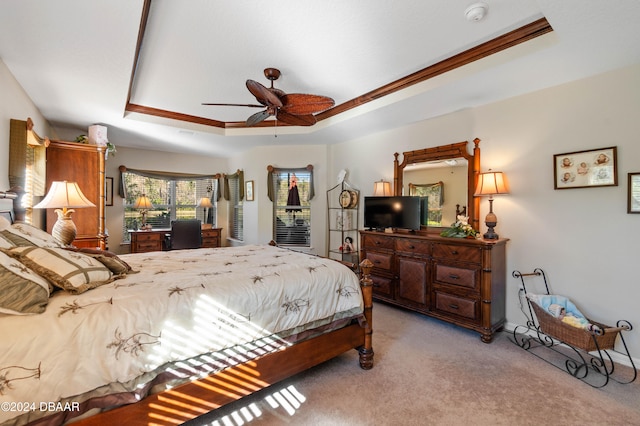 carpeted bedroom with a raised ceiling, ceiling fan, and crown molding