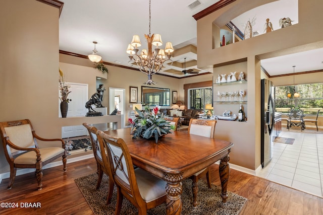 dining space featuring hardwood / wood-style floors, ceiling fan with notable chandelier, and ornamental molding