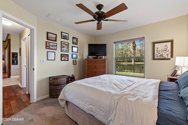 bedroom featuring ceiling fan, a textured ceiling, and hardwood / wood-style flooring