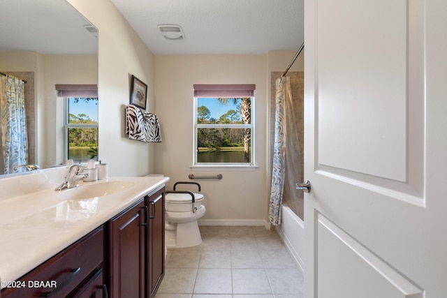 full bathroom featuring tile patterned floors, vanity, toilet, and a wealth of natural light