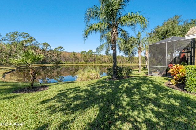 view of yard featuring a lanai and a water view